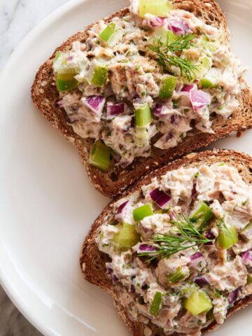 Overhead view of homemade tuna salad toast recipe with chunky filling on toasted multigrain bread
