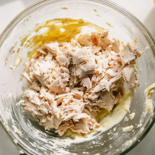Mixing tuna, mayo, and mustard in a bowl to create the creamy base