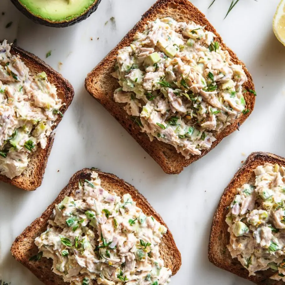 Tuna salad spread over toast with optional toppings on the side