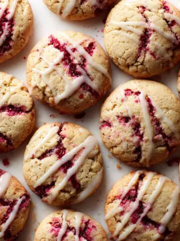 Freshly baked raspberry lemonade cookies recipe with glaze, imperfectly arranged on a white kitchen counter