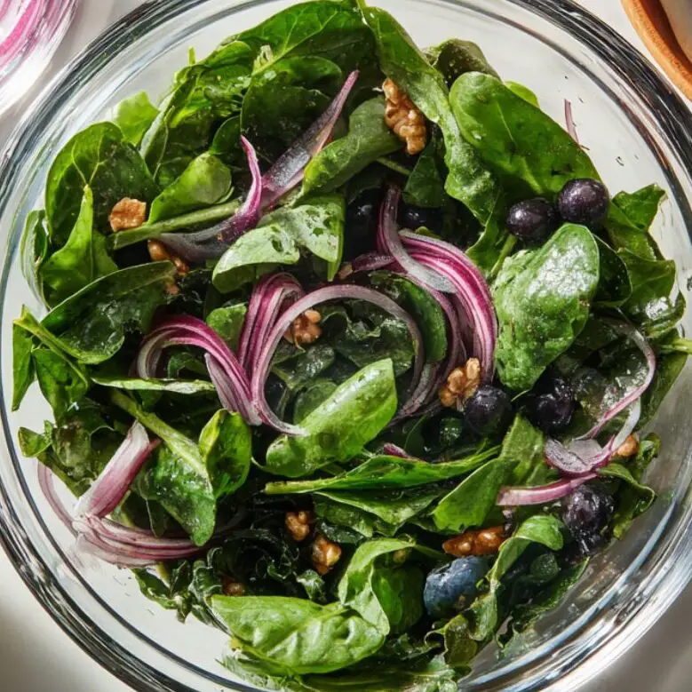Washed greens, blueberries, toasted walnuts, and sliced onion ready for salad.
