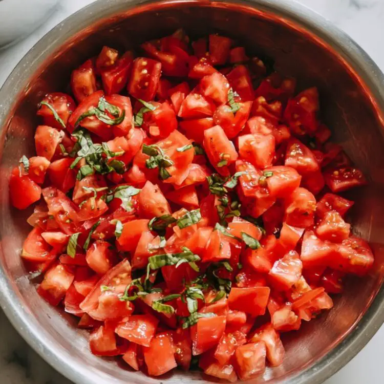 Diced tomatoes, basil, garlic, and boiling water prepared for cooking spaghetti.
