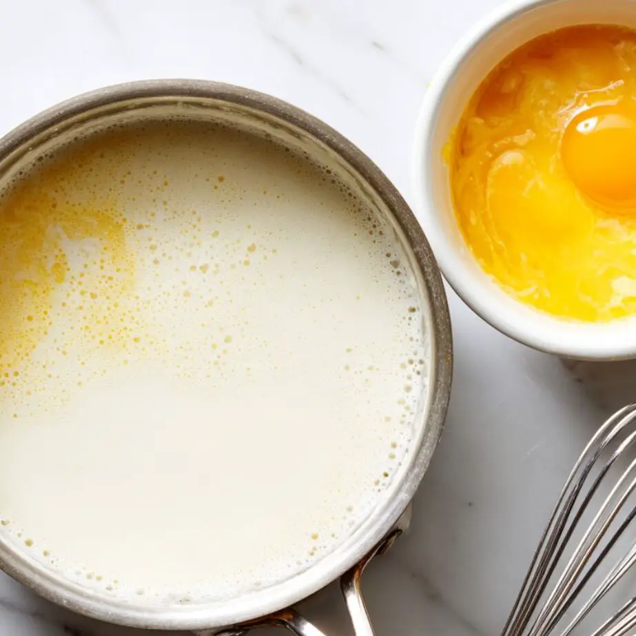 Heating milk and cream with whisked egg yolk mixture ready beside it.