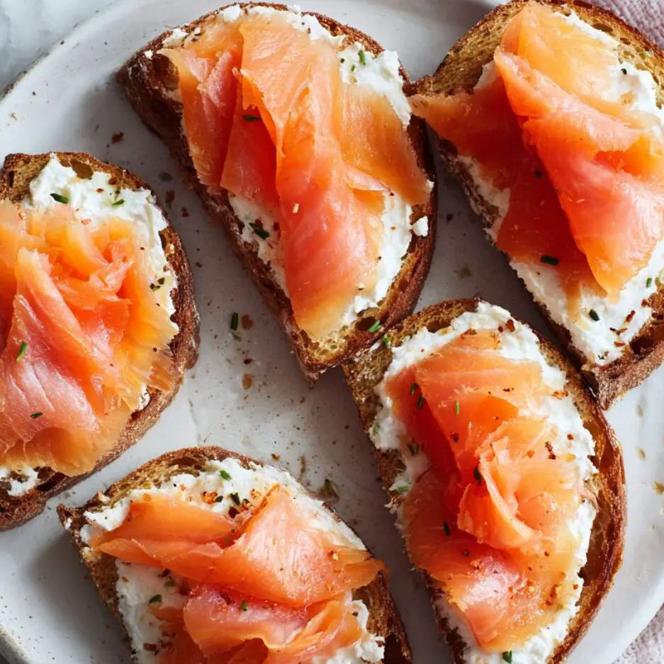 Cream cheese toast topped with folded smoked salmon slices.