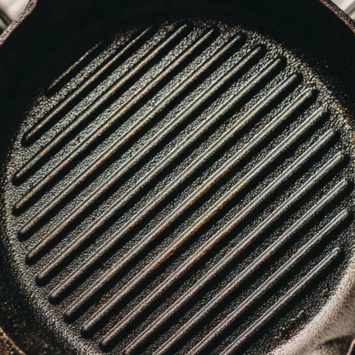 Cast-iron pan and grill setup ready for Tuscan steak cooking.
