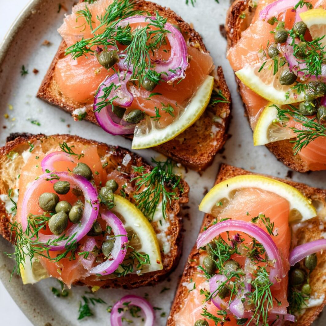Smoked salmon toast with dill, capers, onions, and lemon juice added on top.