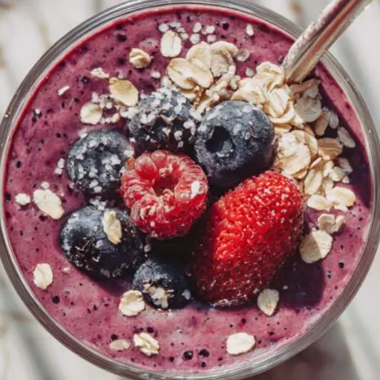 Freshly served smoothie with toppings on kitchen counter