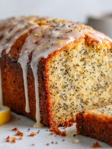 Homemade lemon poppy seed pound cake recipe sliced with lemon glaze on white kitchen counter, overhead view.