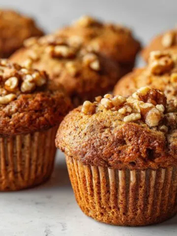 Homemade vegan banana nut muffins recipe on a white kitchen counter, photographed from above with a rustic homemade look.