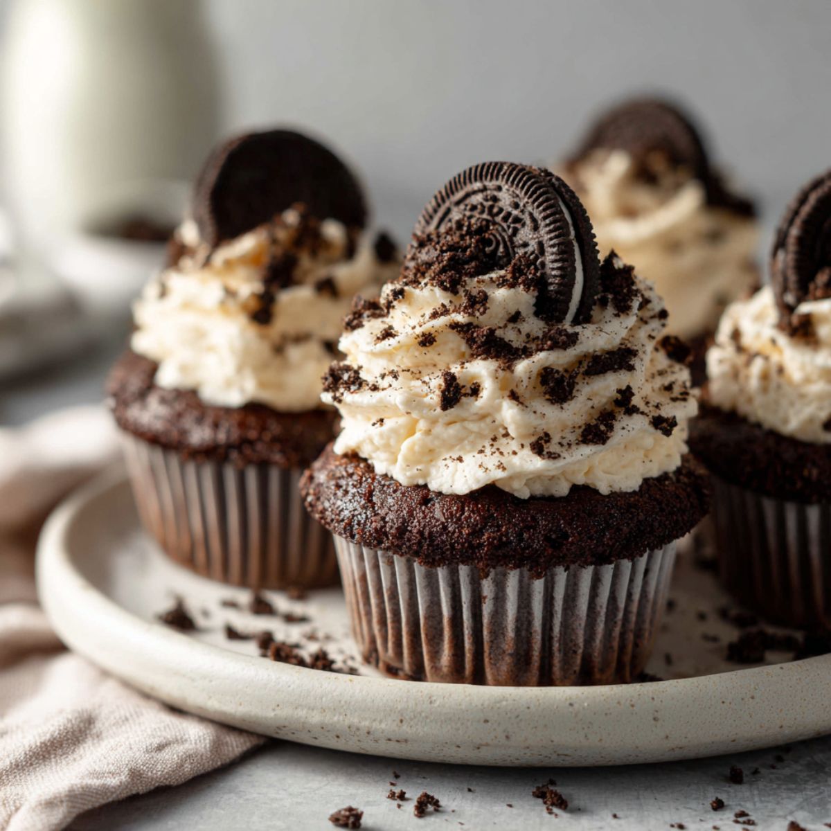 Homemade Oreo cupcakes recipe with buttercream and crushed cookies on a white kitchen counter, photographed from above.