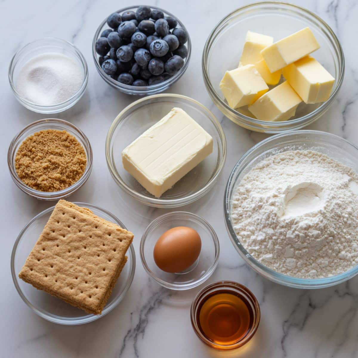 Overhead view of fresh blueberries, cream cheese, butter, sugar, flour, and other ingredients for blueberry cheesecake cookies on a kitchen counter.