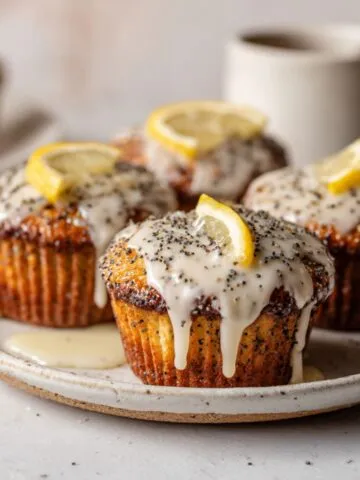 Homemade lemon poppy seed cupcakes recipe with glaze on a white kitchen counter, overhead shot with rustic and imperfect look.