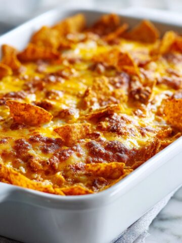 Homemade Taco Dorito Casserole Recipe fresh out of the oven with melted cheese and crunchy Doritos on a white kitchen counter, photographed from above.