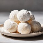 Homemade milk mochi recipe balls dusted with cornstarch on a white marble counter, captured from above in natural light for a real homemade look.